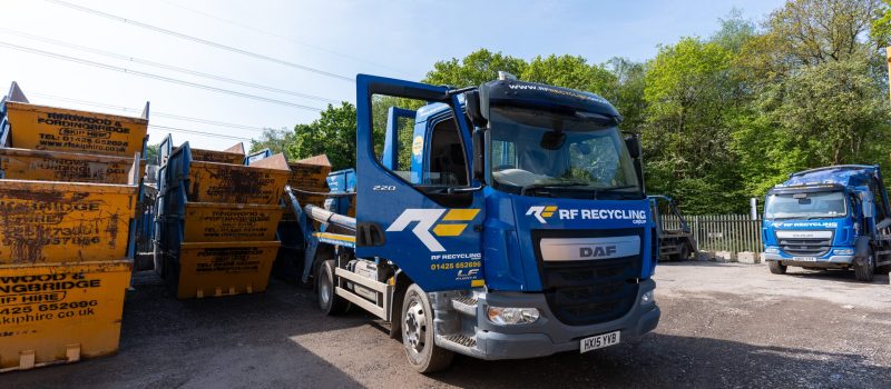 multiple RF skips in a pile next to a RF lorry