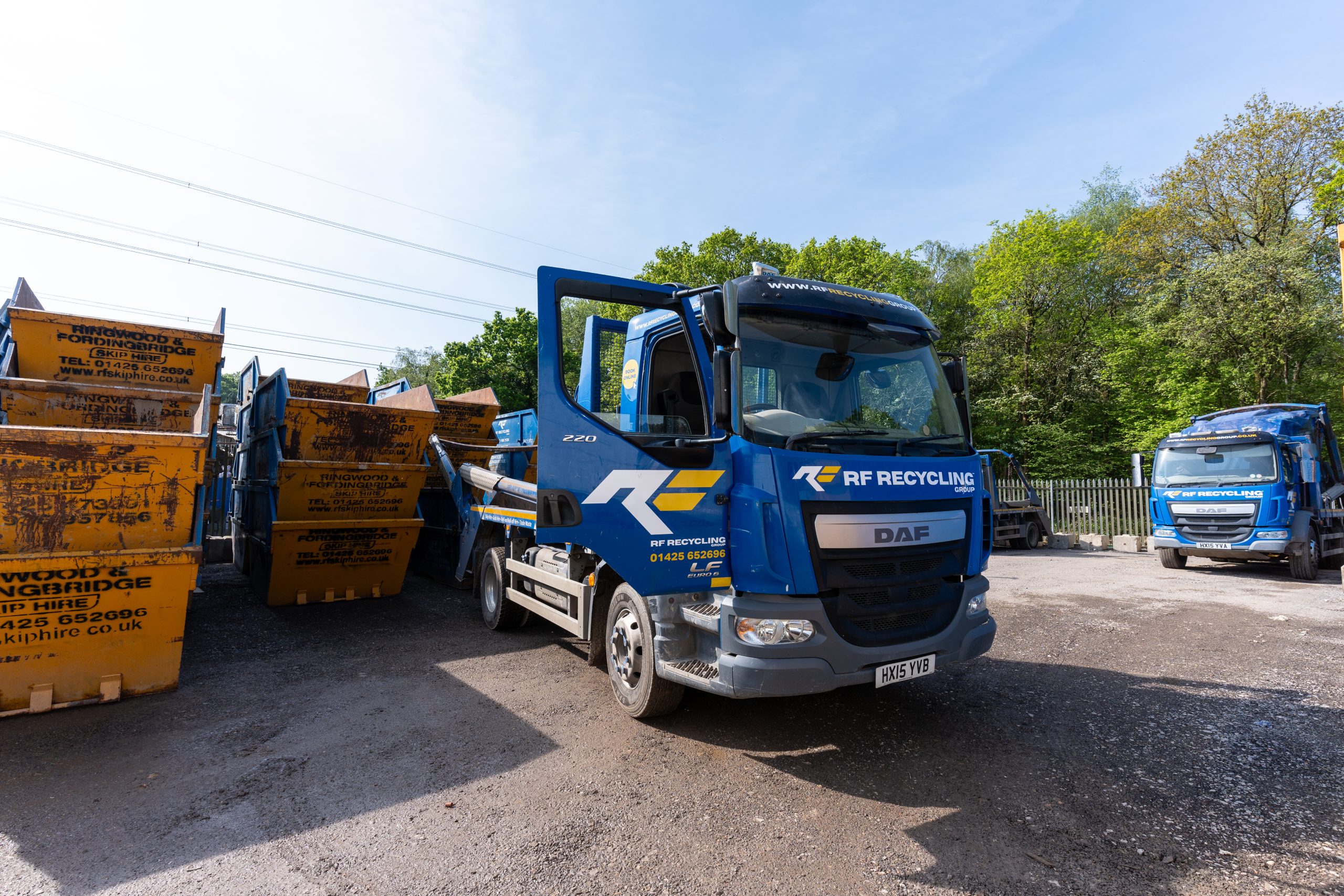 multiple RF skips in a pile next to a RF lorry