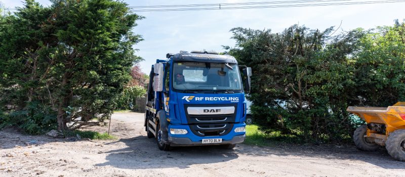 a truck carrying a mini skip